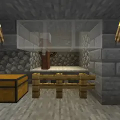 W klatce z Minecrafta stoi villager, gotowy na komendę na zabicie mobów. Obok skrzynia i pochodnie.
