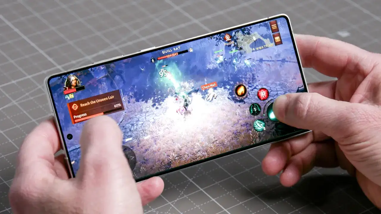Ręce trzymają smartfon, na którym widać dynamiczną grę akcji. To jedne z najlepszych gier na telefon, wciągające w wirtualny świat.
