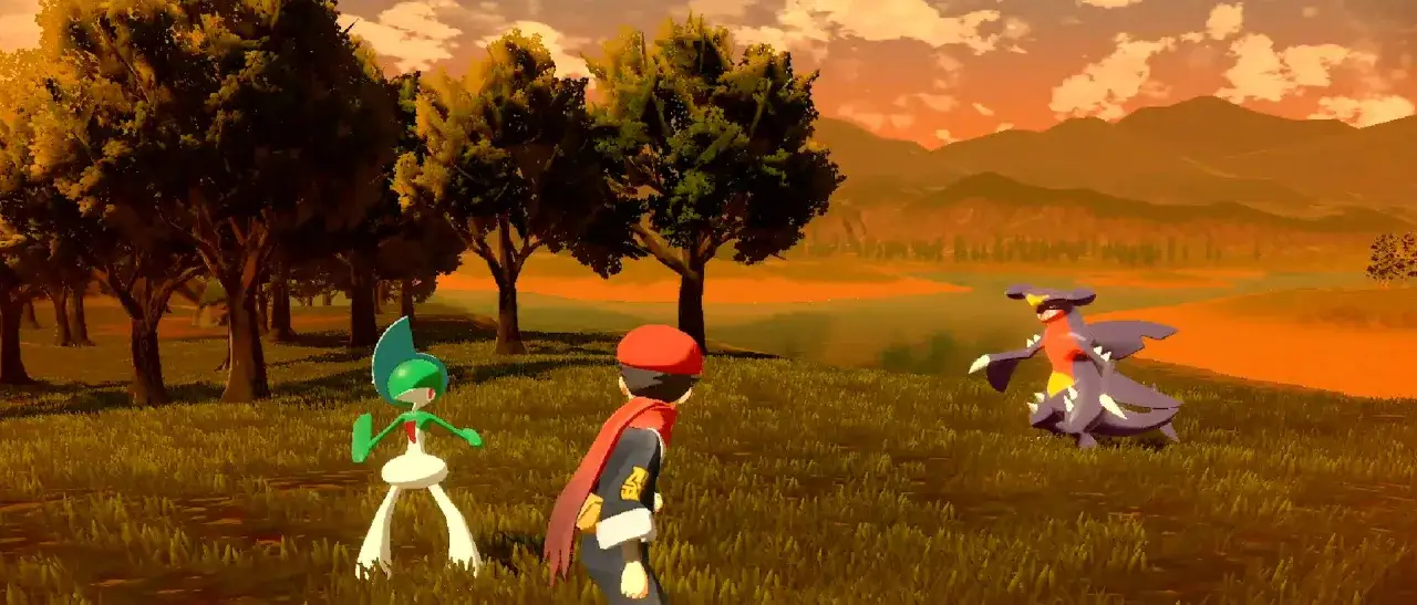 Gracz z Pokémon Legends: Arceus staje naprzeciw Garchompa i Raltsa na tle zachodzącego słońca.